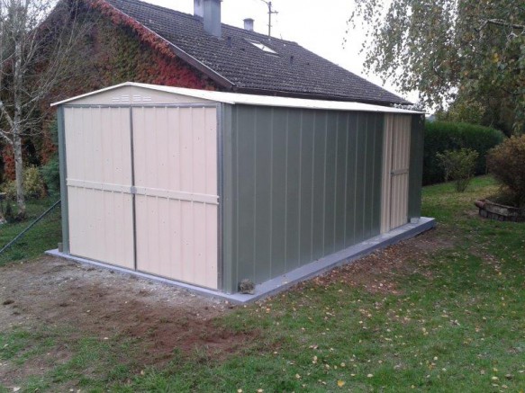 garage en métal vert et crème dans jardin