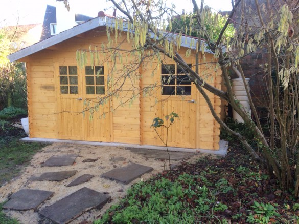 Grand abri de jardin en bois avec allée en pierres