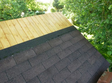 Le toit fortement incliné d'un abri de jardin en bois 