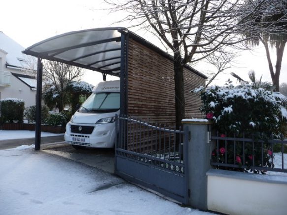 Un abri pour camping-car avec bardage bois sur le côté 