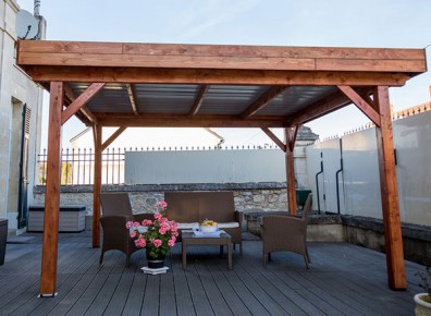 Une tonnelle toit plat en bois lamellé adossé pour se prémunir du soleil et de la pluie !