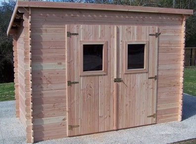 Un cabanon en bois avec porte double battants et ouvertures