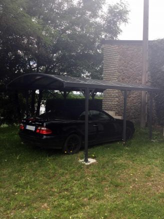 Un carport en aluminium équipé de son toit berceau pour protéger son véhicule 