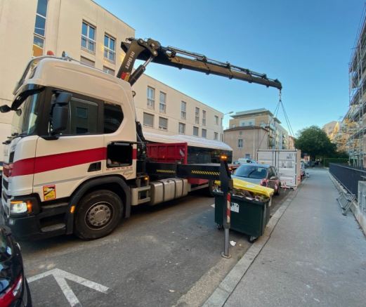 un container de stockage mobile en train d'être chargé sur un camion